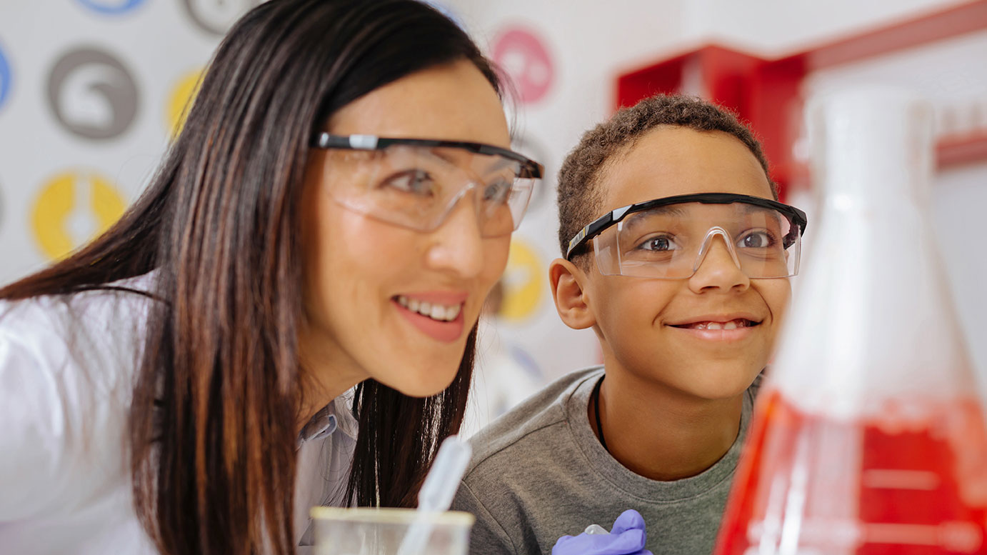 Chemielehrerin mit interessiertem Kind (Foto: Adobe stock #198943678, Viacheslav Yakobchuk)